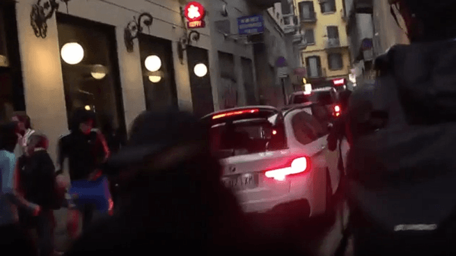 L'auto accelera in un vicolo del centro di Milano per sfuggire ai manifestanti: spaccano il vetro del lunotto posteriore e scappano via
