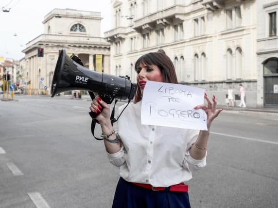 Milano, annunciato un corteo in difesa di Roggero, ma si presenta solo l'organizzatrice, con il megafono e un cartello