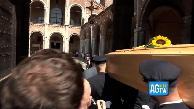 L'arrivo del feretro di Don Mazzi in Sant'Ambrogio: applausi e un girasole sulla bara